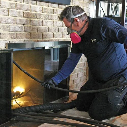 Technician evaluating a brick fireplace and chimney connection